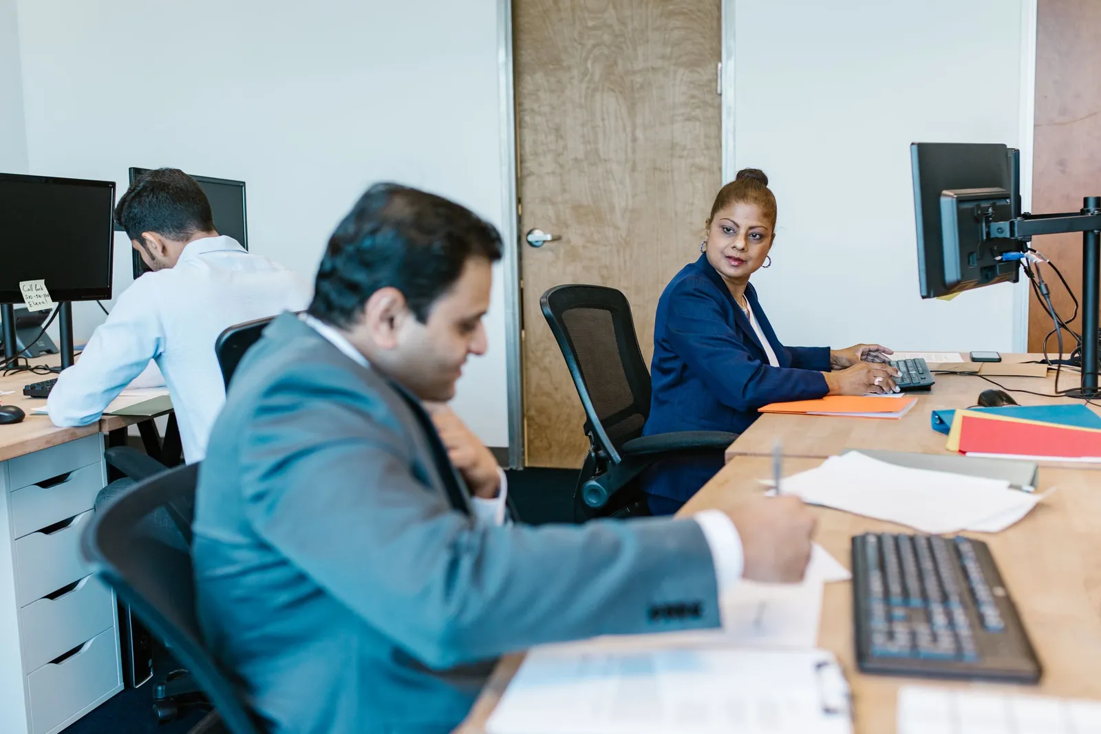 Colleagues working through tasks together at their desks